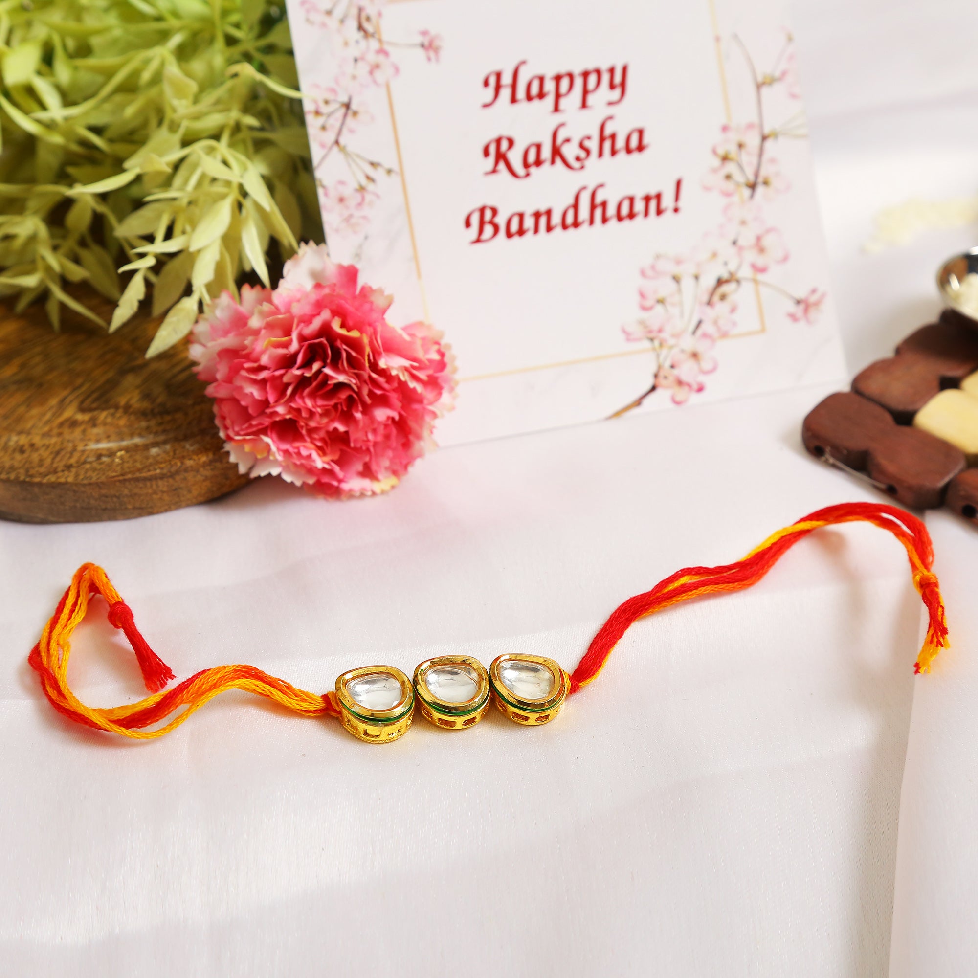 Gold Tone Kundan Rakhi with red yellow cotton thread